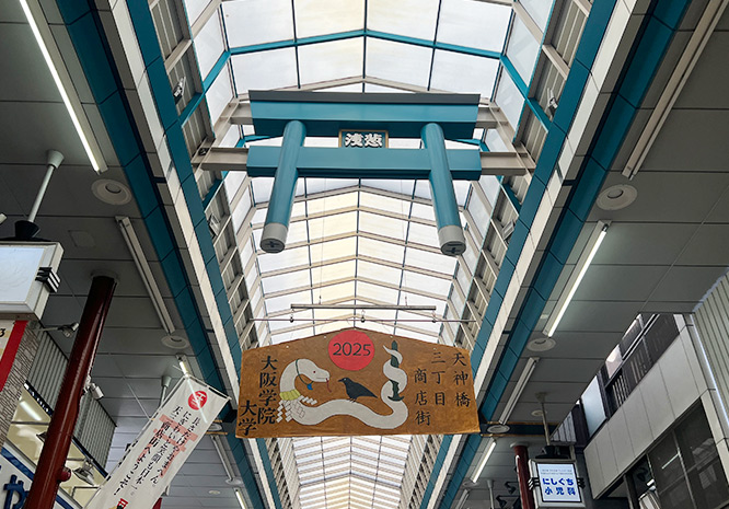 学生制作の巨大絵馬を天神橋三丁目商店街に設置の様子